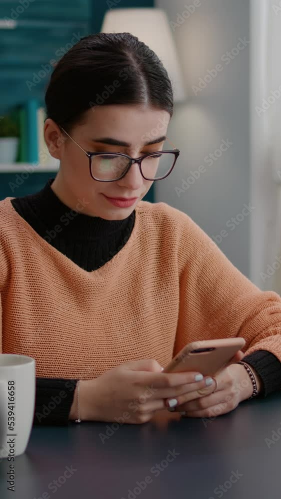 Poster vertical video: college student browsing internet on smartphone to do reseacrh for online school ass
