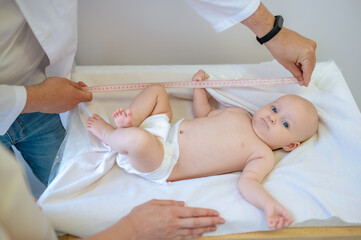 Pediatrician measuring babys body part during medical check up