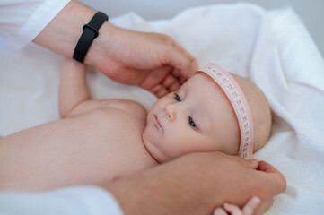 Fototapeta na wymiar Pediatrician measuring babys body part during medical check up