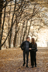 Lovely couple posing in autumn forest, lovers walking in park. lovestory in forest