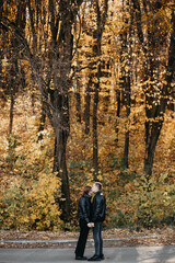 Fototapeta premium Lovely couple posing in autumn forest, lovers walking in park. lovestory in forest