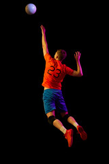 Energy, power and sport. Professional volleyball player playing volleyball isolated on dark background. Art, sport, team, competition, championship
