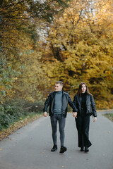 Fototapeta premium Lovely couple posing in autumn forest, lovers walking in park. lovestory in forest