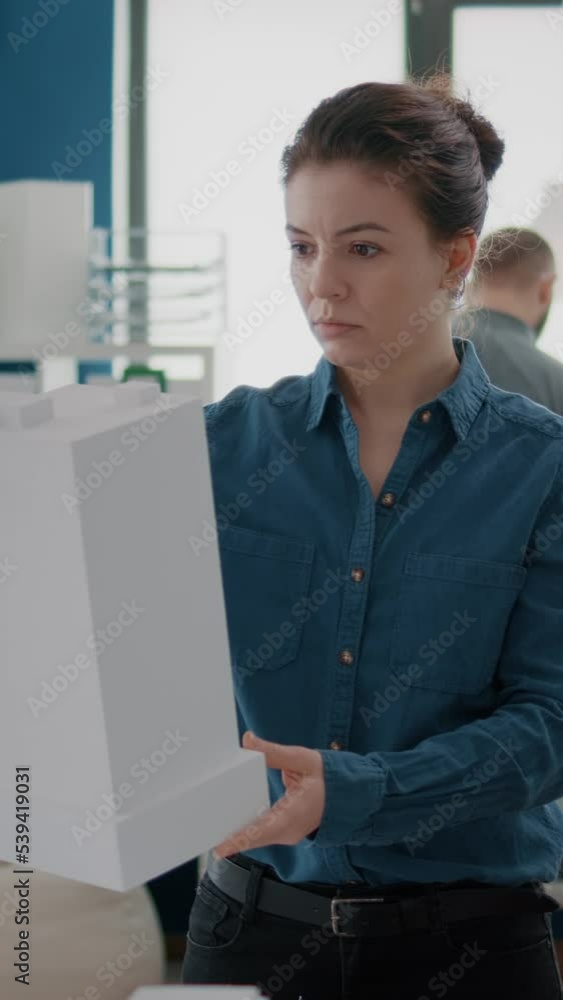 Poster portrait of woman architect analyzing building model to create urban project structure. industrial c