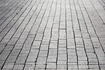 Stone pavement texture, cobbled street in sunlight. Road from tiles for background