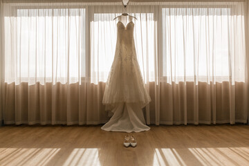 Hochzeitsvorbereitungen der Braut, Brautkleid am Fenster