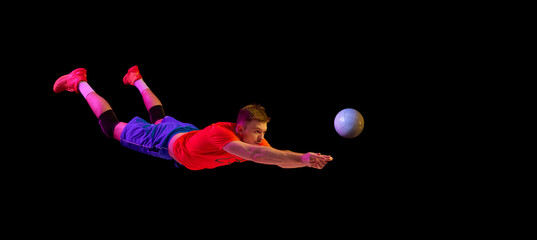 Energy, power and sport. Professional volleyball player playing volleyball isolated on dark background. Art, sport, team, competition, championship