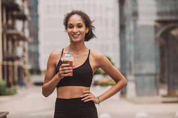 Pretty young sportive girl with a cup of coffee