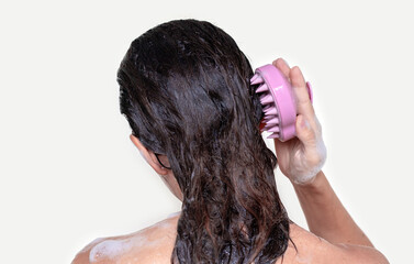 hair growth stimulating,scalp massage.woman using  pink scalp massager shampoo brush with...