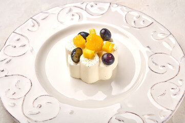 Panna cotta homemade with natural vanilla pod, mango and grape, high key, close up
