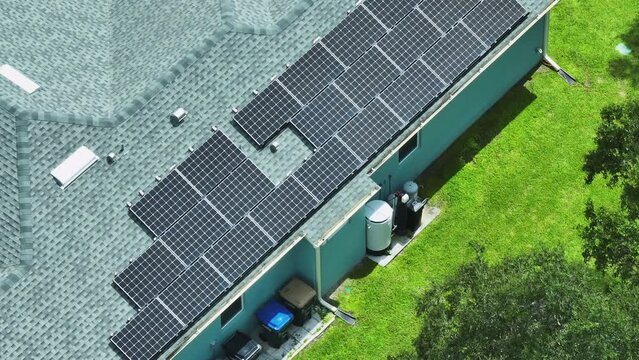 Aerial view of typical american building roof with rows of blue solar photovoltaic panels for producing clean ecological electric energy. Renewable electricity with zero emission concept