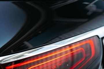 Modern car headlight of a black luxury car close up