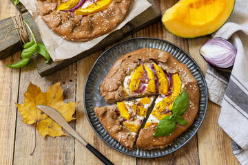 Homemade galette pie or crostata with pumpkin and ricotta cheese on rustic  background. Thanksgiving day food.