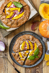 Homemade galette pie or crostata with pumpkin and ricotta cheese on rustic  background. Thanksgiving day food. View from above.