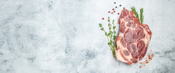 Pork meat with herbs and spices on a light background. Long banner format. top view