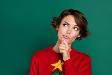 Photo of minded lady ornament clothes sweater arm touch face look empty space consider solution isolated on green color background