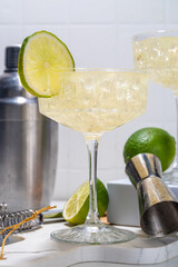 Sour alcoholic lime gin gimlet drink. Lemonade martini alcohol boozy cocktail garnished with lime,...