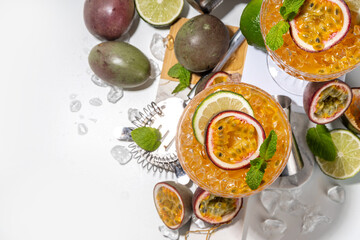 Passion fruit martini cocktail. Sweet pornstar alcoholic drink with fresh passion fruit and lime, with bar utensils copy space