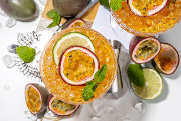 Passion fruit martini cocktail. Sweet pornstar alcoholic drink with fresh passion fruit and lime, with bar utensils copy space