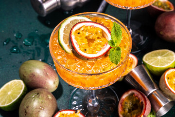 Passion fruit martini cocktail. Sweet pornstar alcoholic drink with fresh passion fruit and lime, with bar utensils copy space