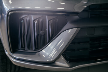 headlight and radiator grille of a beautiful matte gray car