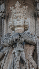 Wall figures of king and queen protected by fishnet at main facade of Justice Department in Magdeburg, Germany, closeup, details