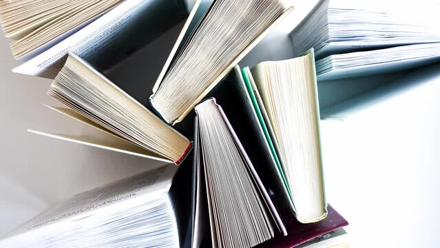 4k zoom in out Stack of old book education concept background, many books piles with copy space for text, Book tops, Old and used hardcover books, top view. Educational concept. Close up