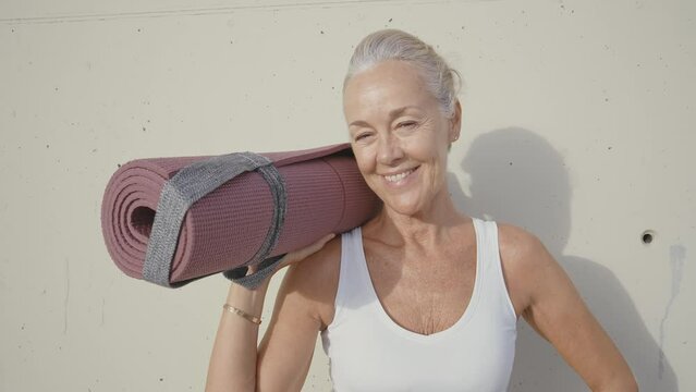 Cinematic footage of a beautiful senior fashion influencer with silver hair and fashionable style. Elderly active woman doing activities outdoor in a modern part of the city