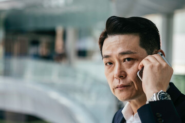 Close Up Photo Of A Businessman Talking On A Mobile Phone And Looking At Camera At Office Balcony