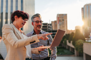 Business partners working on laptop in city