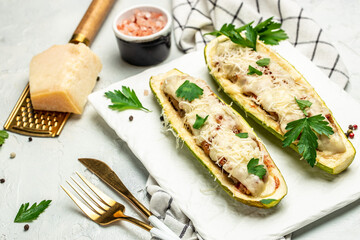 Zucchini stuffed with minced meat and cheese on a light background. Restaurant menu, dieting, cookbook recipe top view