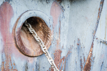 A stranded ship on the bank of the Danube river. Anchor hole with a chain on the bow of a stranded ship on the bank of the Danube.