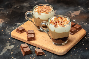Dessert three chocolate in a glass jar on a wooden board. Food recipe background. Close up