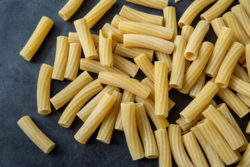 Raw italian penne rigate pasta isolated on black background