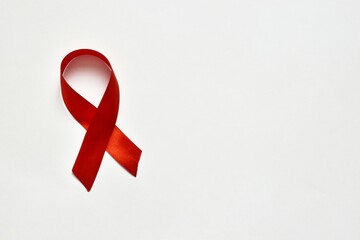 Red ribbon on a white background. The symbol of The World AIDS Day or cancer or HIV Awareness Month. concept of healhcare. Copy space. Banner with copy space