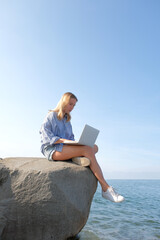 Remote work.Girl freelancer works remotely on the sea shore.workation, remote work,WFVH,Van Life...