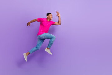 Fototapeta na wymiar Full body profile portrait of active sporty man jumping run hurry empty space isolated on purple color background
