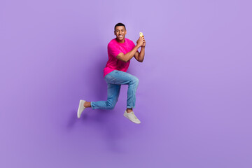 Fototapeta na wymiar Full size profile portrait of active handsome guy jumping rush hold use telephone isolated on purple color background