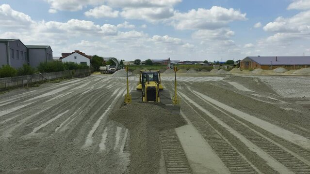 Front, view of large bulldozer or crawler with GPS moving sand at construction site.