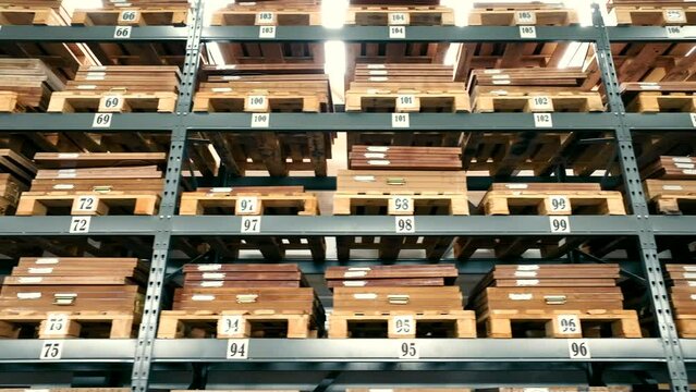 storage of goods on wooden shelves of a large warehouse. Storage of cardboard boxes on wooden pallets