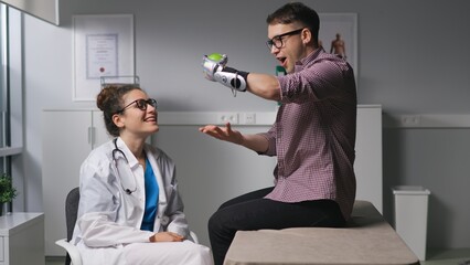 Woman physiotherapist exercises wit patient with hand prosthesis in medical office. 