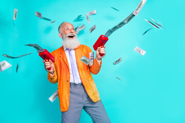 Photo of excited grandfather hold money gun thrown banknotes isolated on teal color background - obrazy, fototapety, plakaty