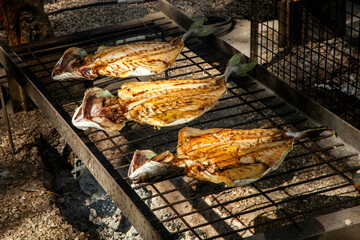 Different types of fish cooked over a fire at a food festival in Estoril, Lisbon.