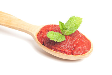 natural tomato paste with mint leaves in wooden spoon isolated on white