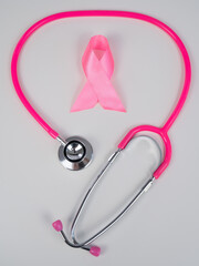 Pink ribbon and stethoscope on a white background. The concept of the fight against breast cancer. 