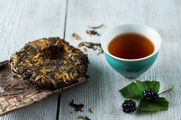 elite tea on wooden old board and a green small cup of tea. top view