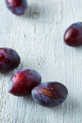 group of ripe plums on old cutting board