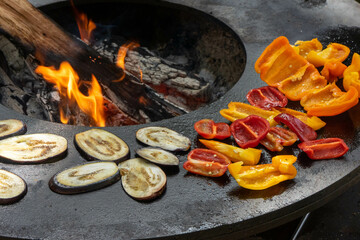 Courgette and red and yellow peppers being cooked over a fire, at a food festival in Estoril, Portugal.
