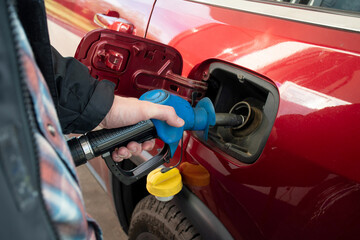 A man hand holding pump filling gasoline. Pumping petrol into the tank. A car refuel on gas station