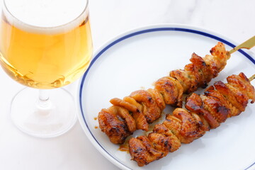 炭火焼にしたタレの焼き鳥（とり皮）をつまみにビールを飲む